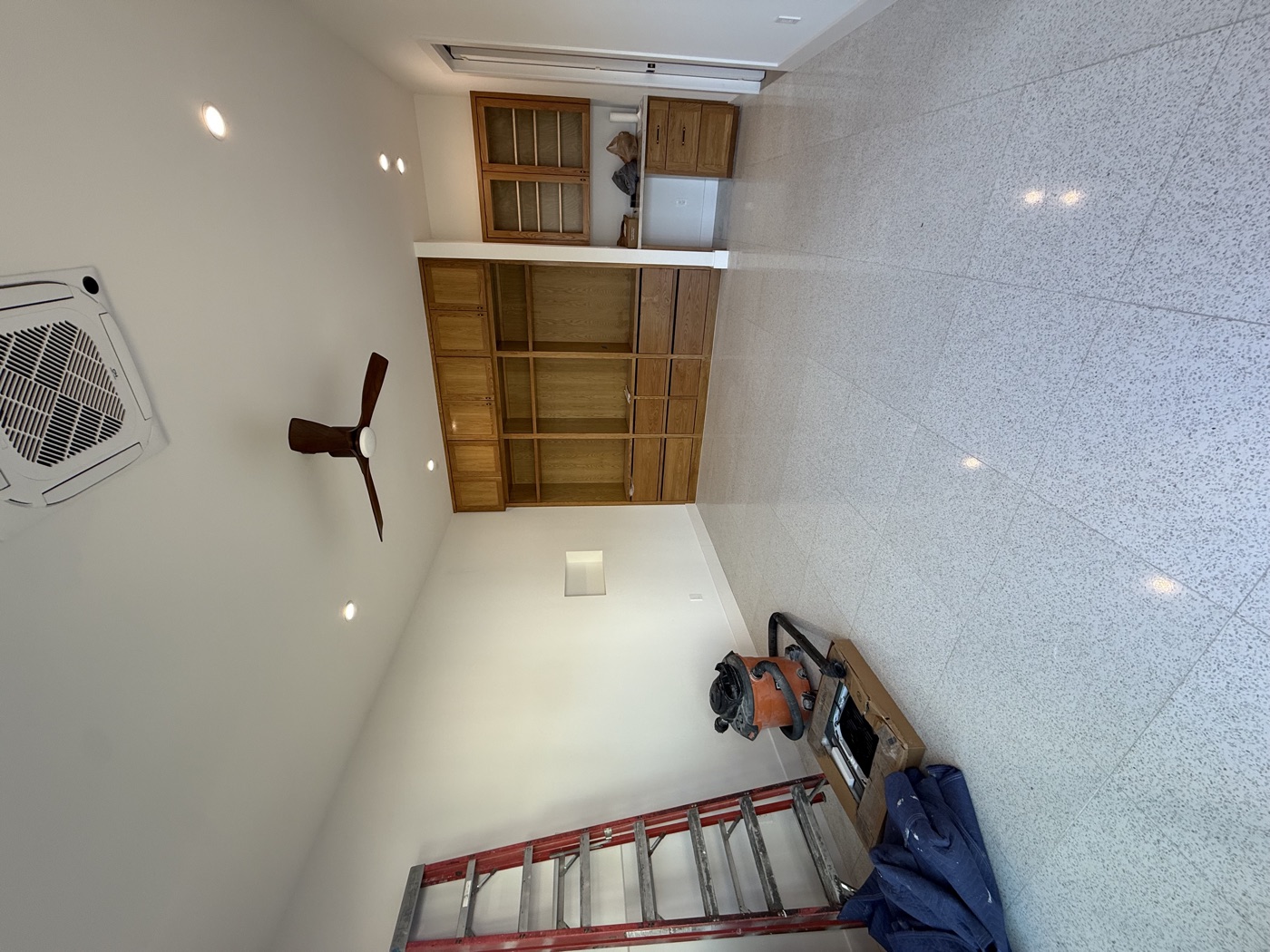 Finished room with built-in wood cabinets and shelving, a desk nook, ceiling fan, recessed lights and terrazzo floor